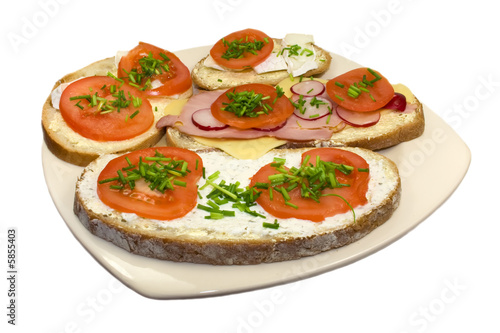 Four sandwich with tomato radish, ham, cheese and chive on plate