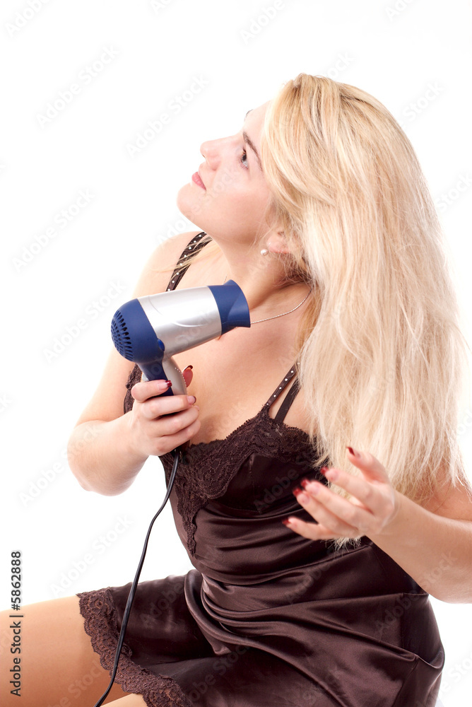 The young woman stacks hair by means of a hair drier The young woman stacks hair by means of a hair drier