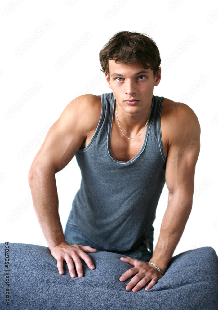 Sexy muscular man leaning on the sofa isolated on white Sexy muscular man leaning on the sofa isolated on white