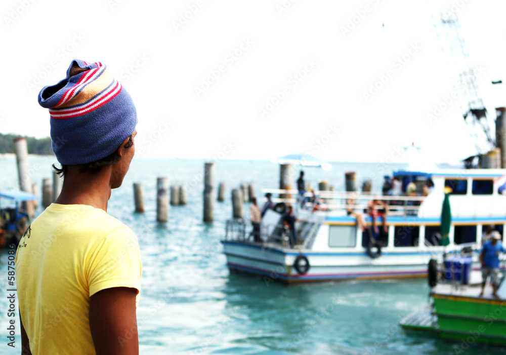 Thai boat worker watches boats at Phi Phi Island, Thailand.