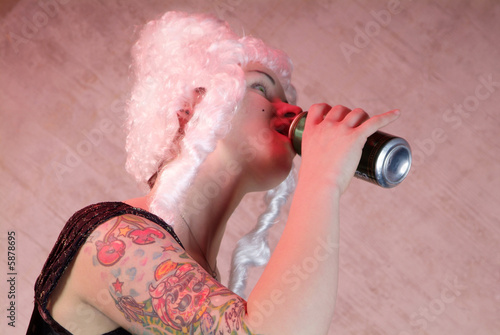 Obraz na plátně woman with white peruke and tattooed , drinks from the can