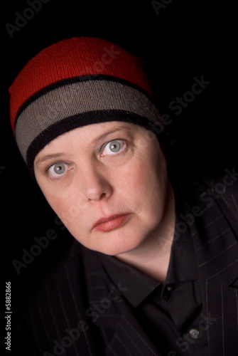Woman wearing a knit hat over a black background