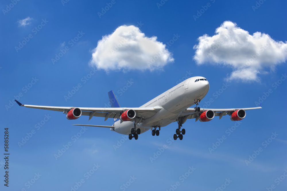 Big airliner and two white clouds on a blue sky Big airliner and two white clouds on a blue sky