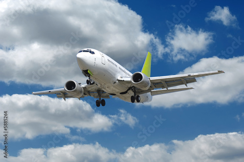 Airliner flying in a blue and cloudy sky.