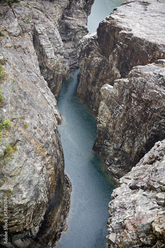 mountain river in narrow gorge among sheer cliffs
