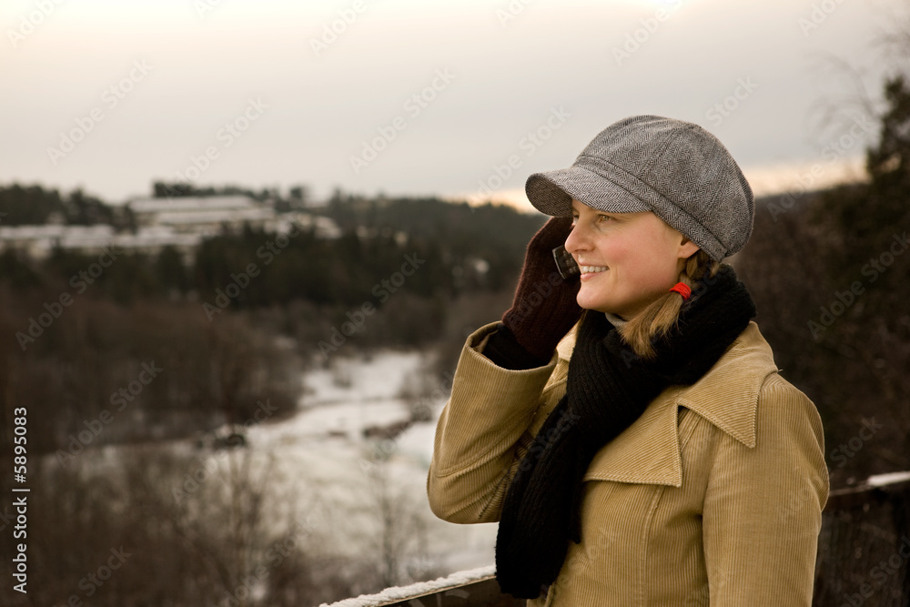 A young woman outside in winter talking on a cell phone