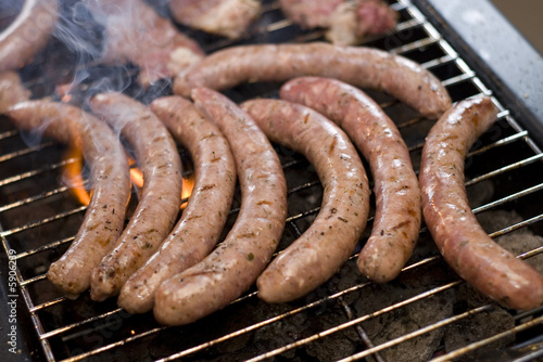 Barbecue sausage on grill with flame and smoke