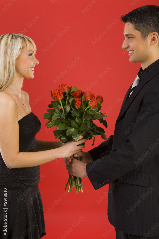 Handsome man in suit is giving beautiful woman roses Handsome man in suit is giving beautiful woman roses