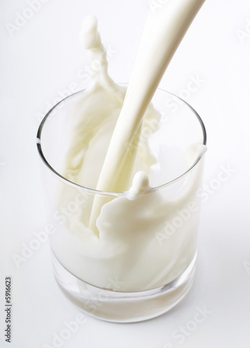 pouring creamy milk in a transparent glass