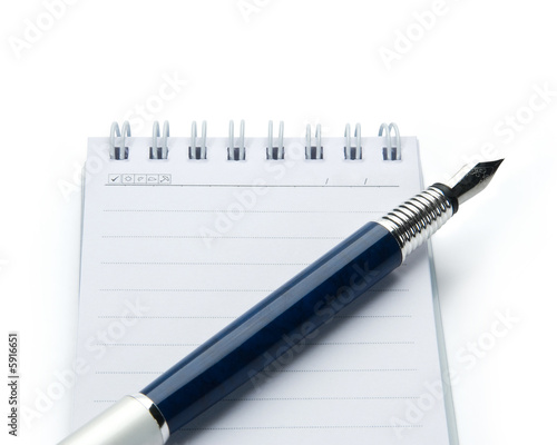 Pen on notebook, isolated on white background.