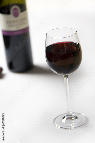 red wine in a glas, bottle on background