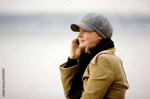 A young woman talking on a cell phone in winter.