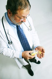 Senior doctor man pouring pills