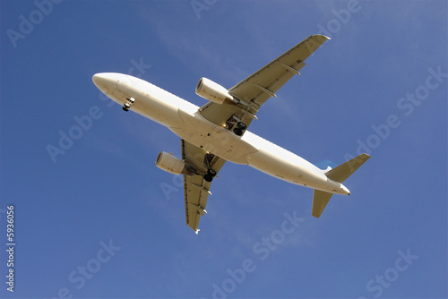 Modern passenger jetliner airplane taking off against blue sky