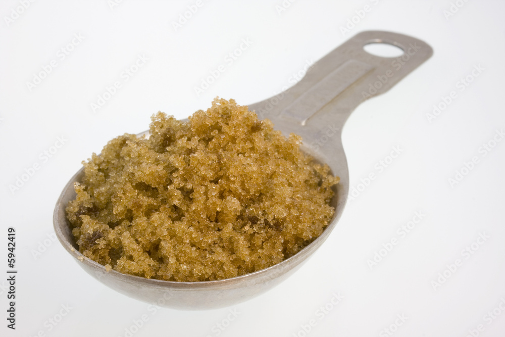 Tablespoon of brown sugar on white Tablespoon of brown sugar on white