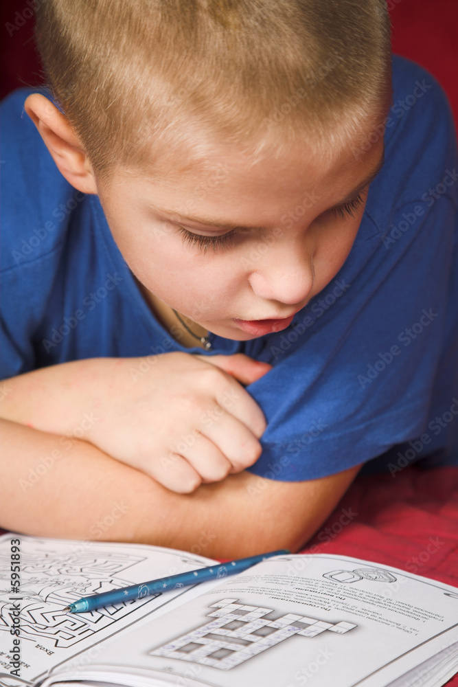 young boy reading book on the red young boy reading book on the red