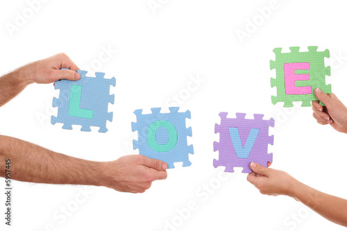 hands holding puzzle with love letters isolated on white