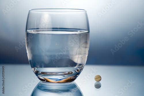 Eine Tablette und ein Glas Wasser