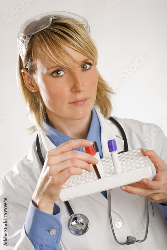 young female doctor holding test tubes with blood photo