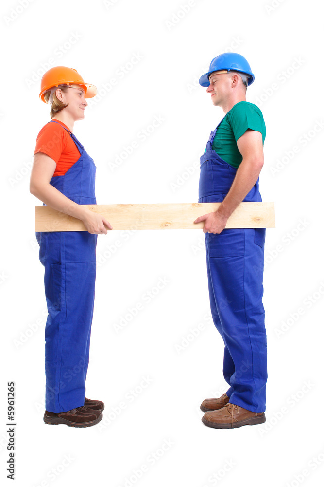Female and male builders holding plank