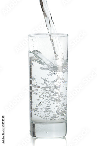 Water poured  to the glass on a white background