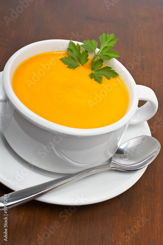 Carrots puree with parsley on wooden background. Shallow DOF