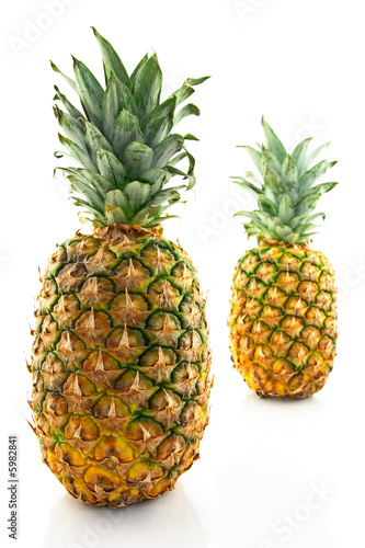 Two ripe pineapples, focus on the closest one.