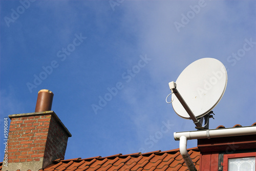 Bild auf Leinwand Parabolic Antenna on red roof
