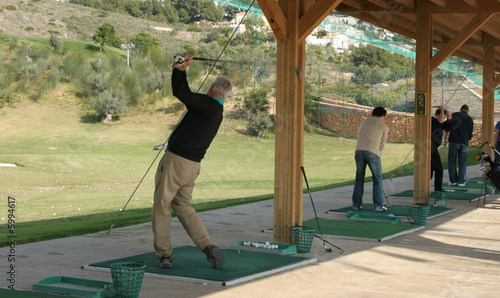 Golfers are practising on a driving range