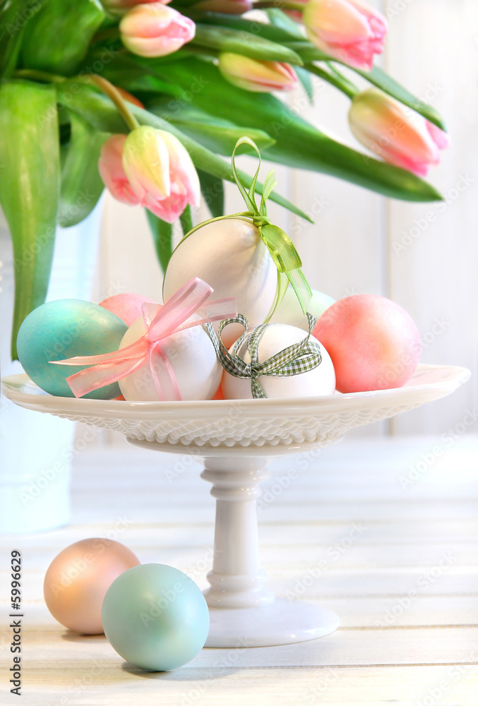 Fototapeta premium Colored eggs with bows and tulips for Easter