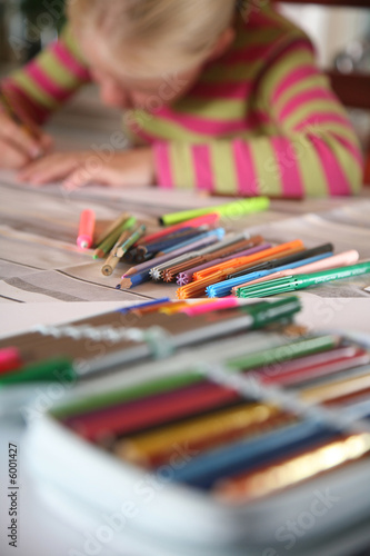 young child writting , painting and playing with colours 
