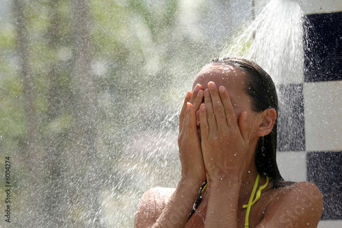 Frau unter der erfrischenden Dusche in der Sonne