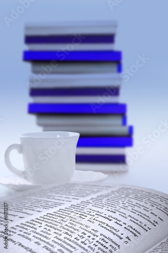 Wörterbuch, Kaffeetasse und Bücherstapel photo