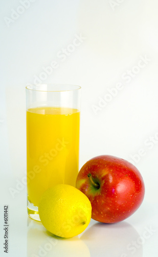 Glass of orange juice, lemon and apple on white background