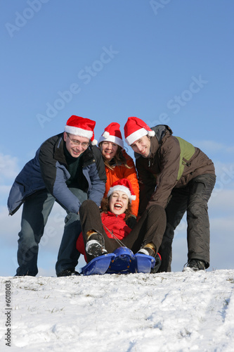 Friends with Santa hats to toboggan in winter