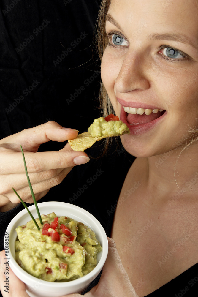 Frau isst chips mit guacamole