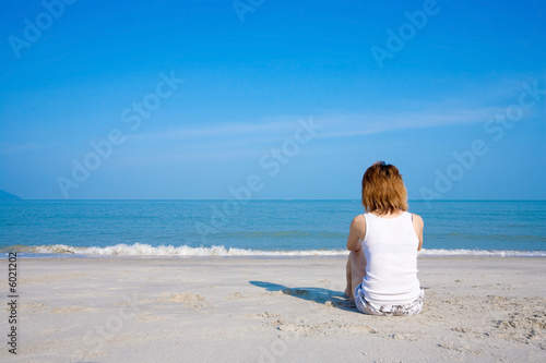 young woman sitting lonely by the beach