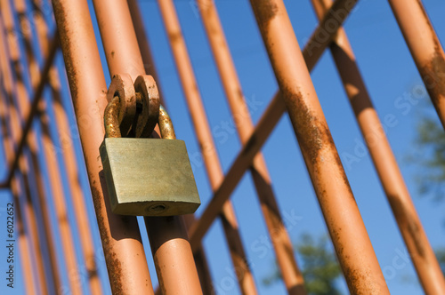 Rusty cage detail painted in red against the sky