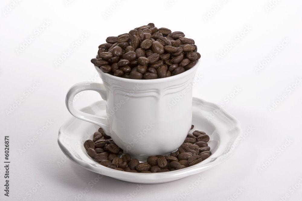Coffee cup full of whole beans with white background Coffee cup full of whole beans with white background