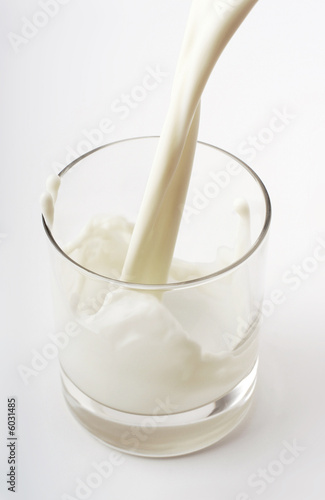 pouring creamy milk in a transparent glass