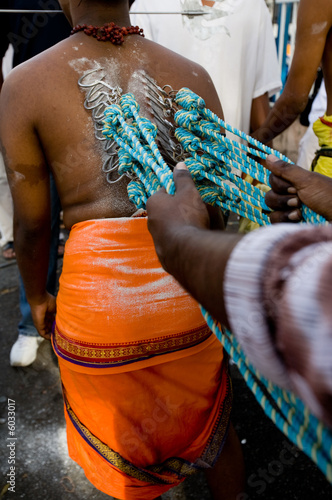 a devotee of thaipusam with hooks piercingh their backs
