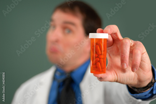 Doctor with questioning look showing bottle of pills