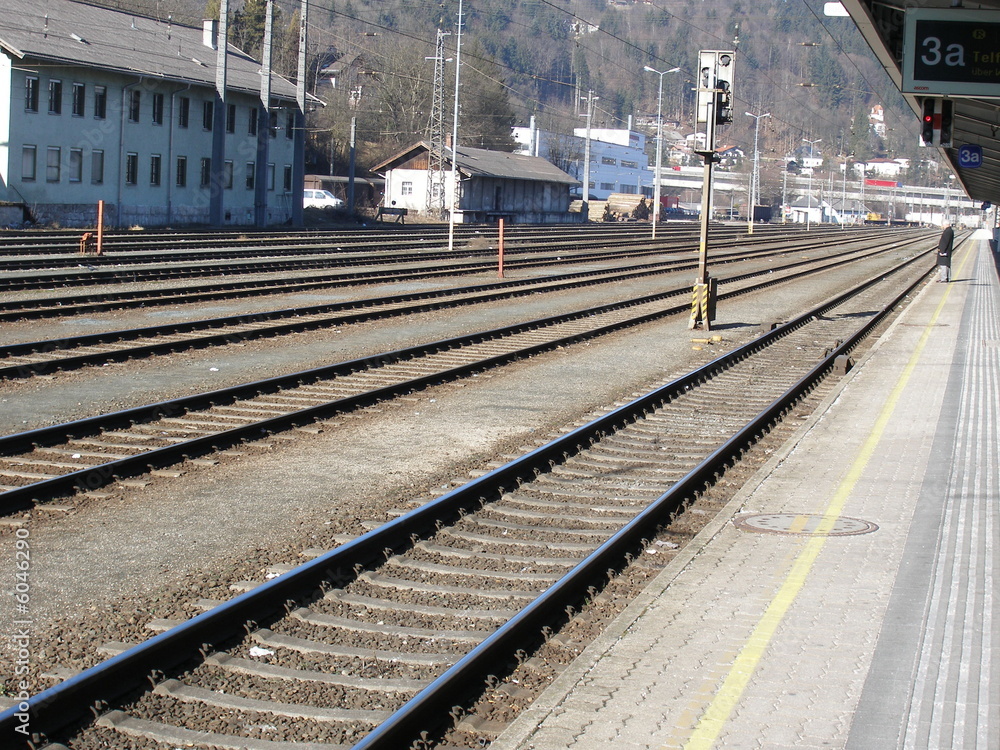 mann steht auf bahnsteig im bahnhof neben geleisen mann steht auf bahnsteig im bahnhof neben geleisen