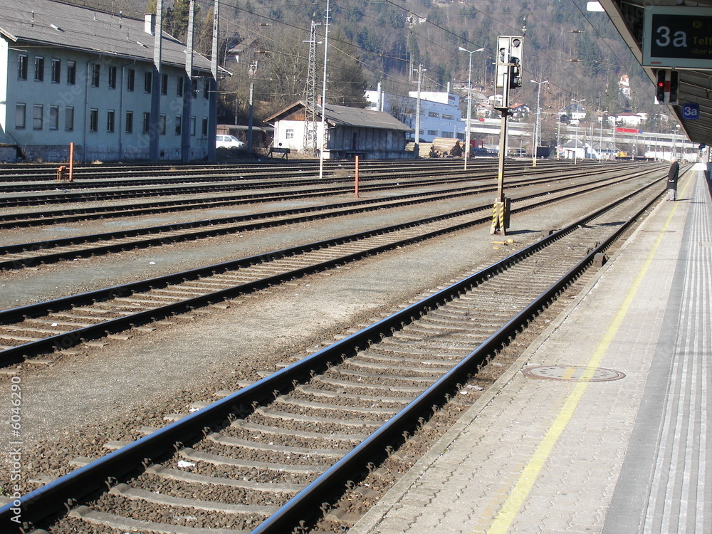 mann steht auf bahnsteig im bahnhof neben geleisen