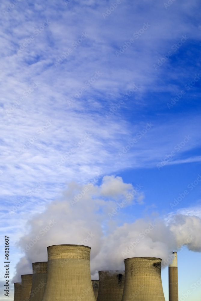 Cooling towers under blue sky with clouds