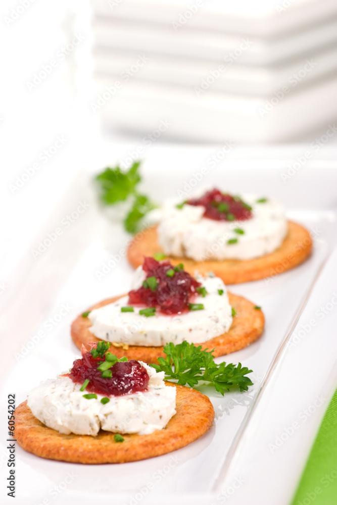 Three crackers with goat cheese and cranberry orange sauce