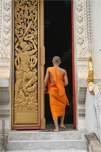 A Buddhist monk walks through the door of a temple in Laos