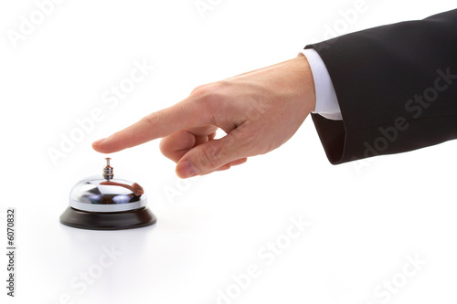 finger of businessman ringing reception bell photo