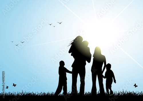 Happy family in a meadow with sun rays
