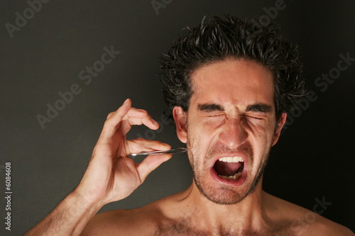 Man pulling his beard with tweezers